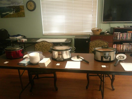 Crockpots set up in a dining room for a meal