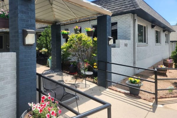 Welcoming entrance with flowers and outdoor seating