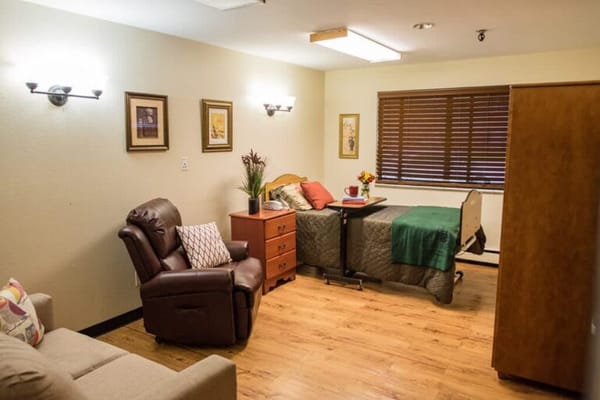 Cozy interior view of a resident's room with bed and chair