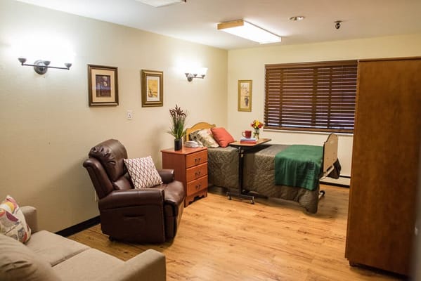 Cozy interior view of a resident's room with bed and chair