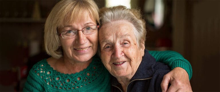 A woman and a senior resident smiling together