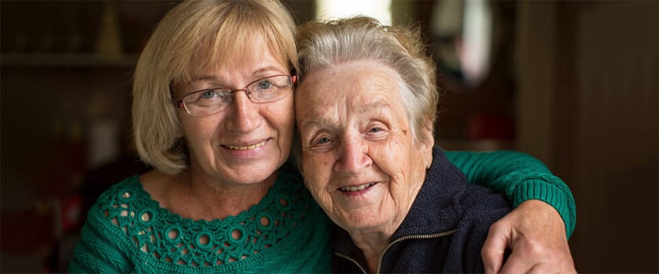 A woman and a senior resident smiling together
