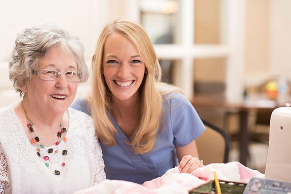 A resident and caregiver smiling during an activity