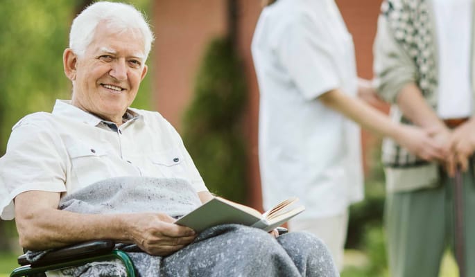 Senior man reading a book in a garden area