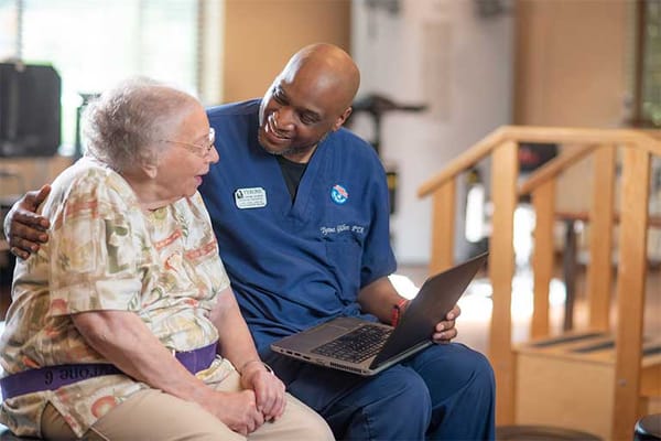 A caregiver and resident sharing a moment in a facility