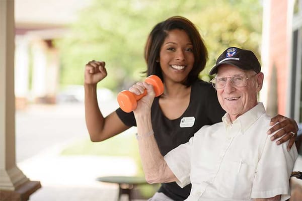 Resident engaging in exercise with staff member