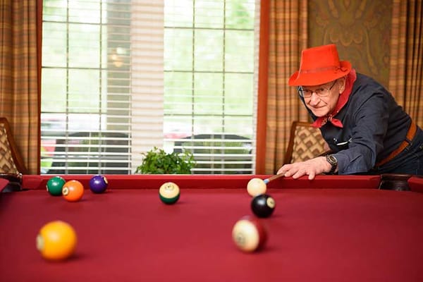 Resident playing billiards in a common area
