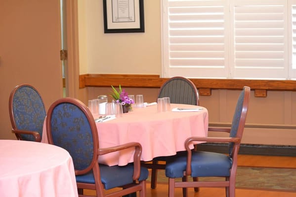 Dining room with pink tablecloths and floral arrangements