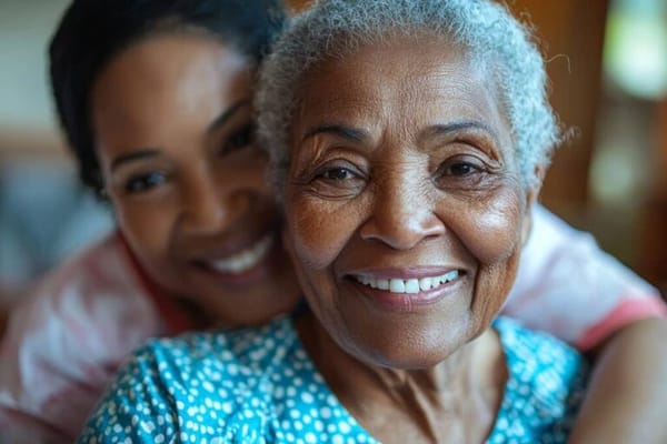 A happy resident with a staff member smiling together