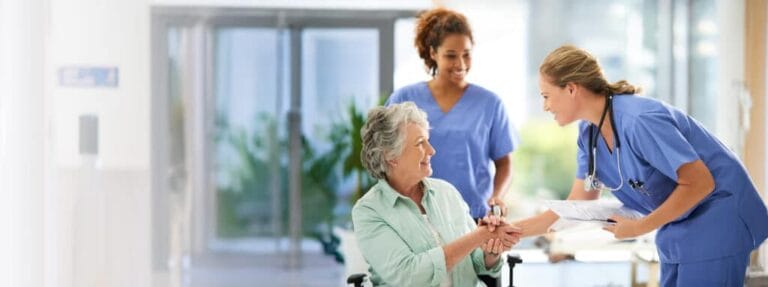 Healthcare staff interacting with a resident in a hallway