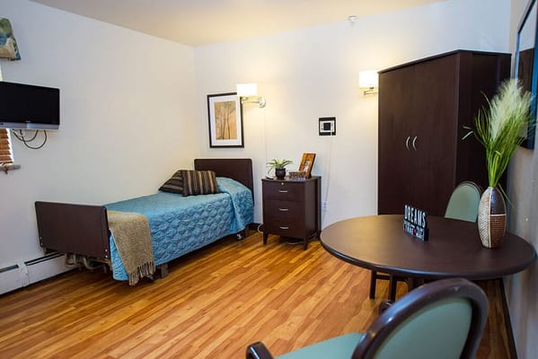 A cozy single resident room with furniture