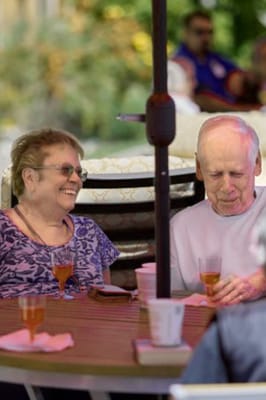 Two seniors enjoying drinks outdoors
