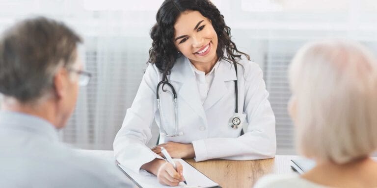 A doctor consulting with senior patients in a bright office