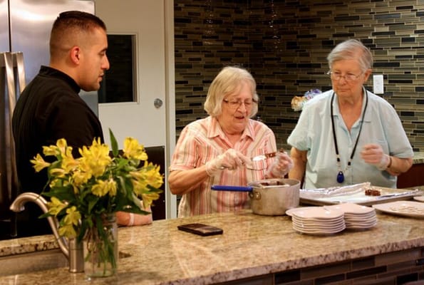 Residents and staff cooking in a modern kitchen