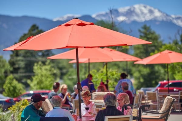 Residents enjoying time outdoors under large umbrellas