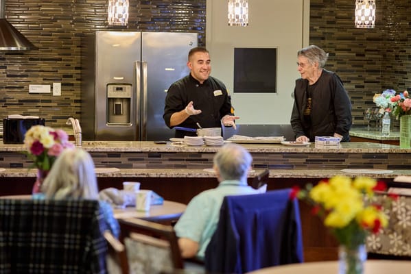 Residents enjoying a meal with staff in a dining area