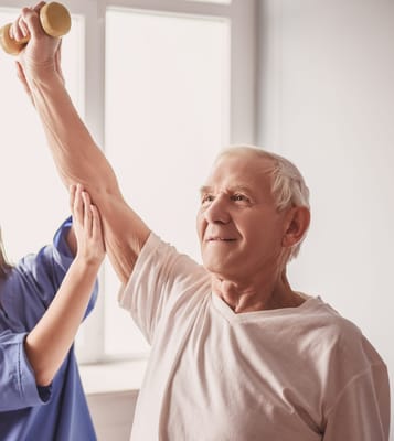 Senior resident exercising with a caregiver