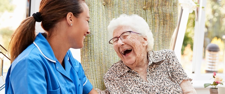 Caregiver and resident sharing a joyful moment