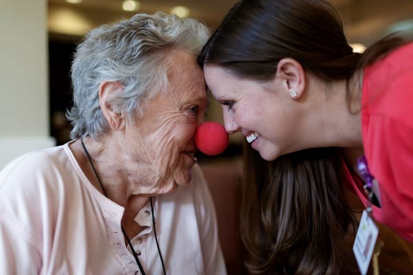 Resident and caregiver sharing a joyful moment with red noses