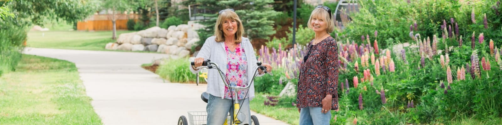 Two women enjoying a walk in a flower-filled garden