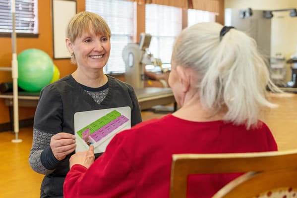 A staff member interacting with a resident in an activity room