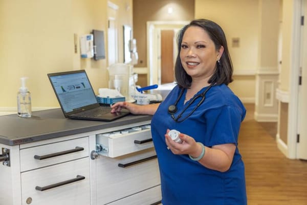 Nurse assisting at a facility with a laptop