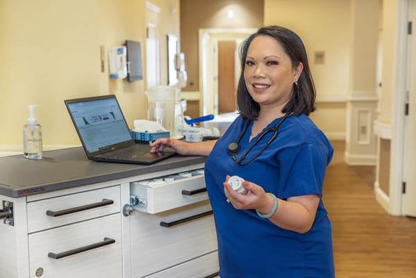 Nurse assisting at a facility with a laptop