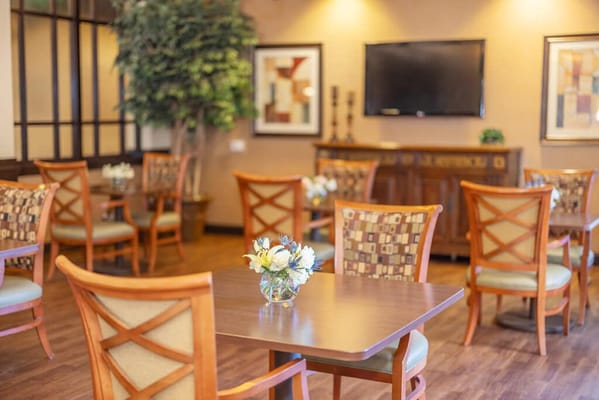 Bright dining area with wooden tables and floral arrangements
