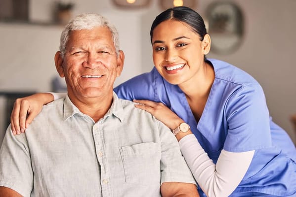 A smiling caregiver with a resident in a cozy interior