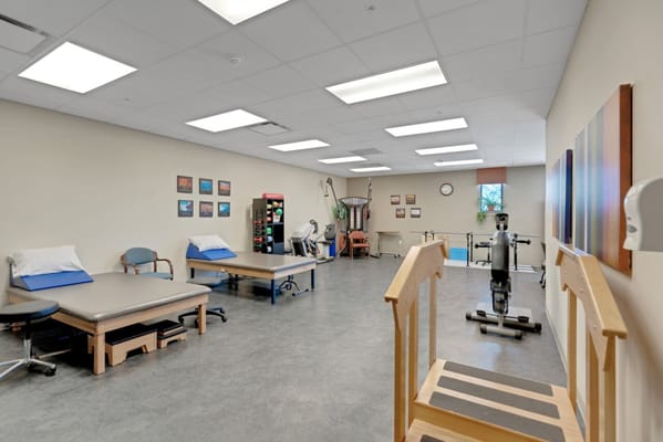 Physical therapy room with equipment and therapy beds