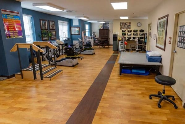 Therapy room with exercise equipment and wooden flooring