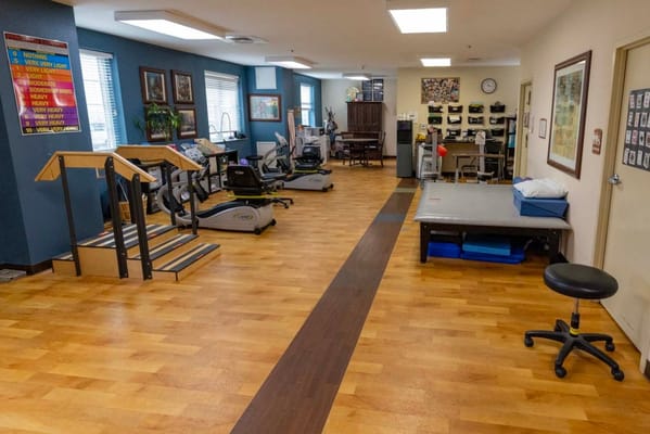 Therapy room with exercise equipment and wooden flooring
