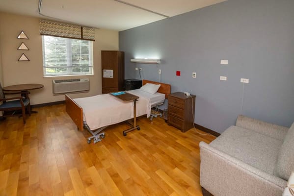 Bright, inviting single resident room with furniture