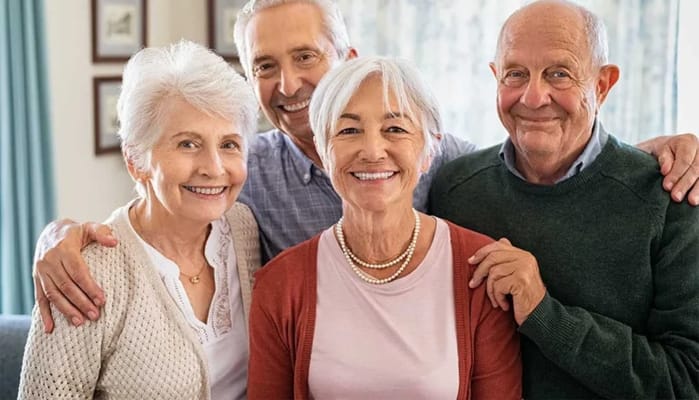 Four smiling seniors posing together in a cozy setting