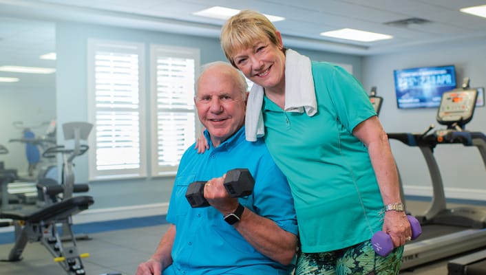 Two seniors exercising in a fitness room