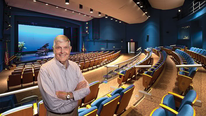 A resident posing in a theater-style common area