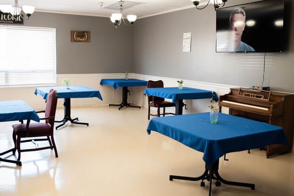 Dining room with blue tables and a piano in the corner