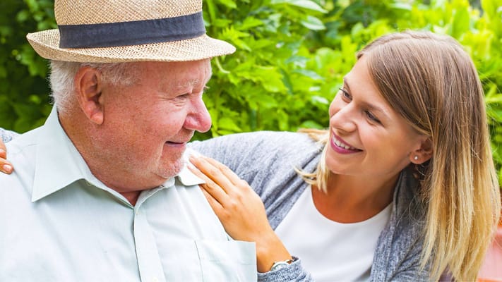 Smiling resident and staff member enjoying conversation outdoors
