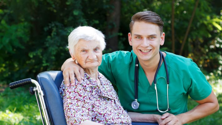 Healthcare worker with a resident in a garden