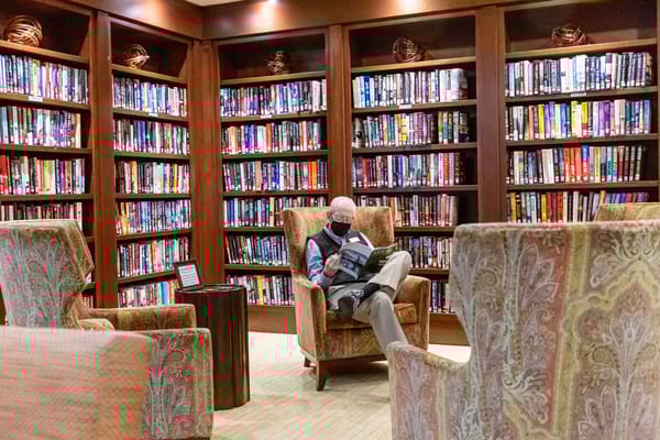 Resident reading in a cozy library filled with books