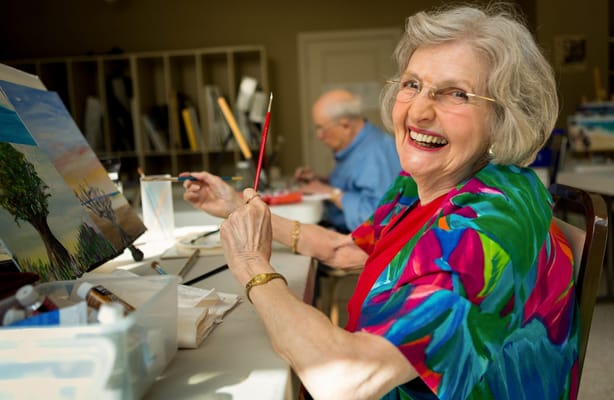 A resident painting in an art activity room