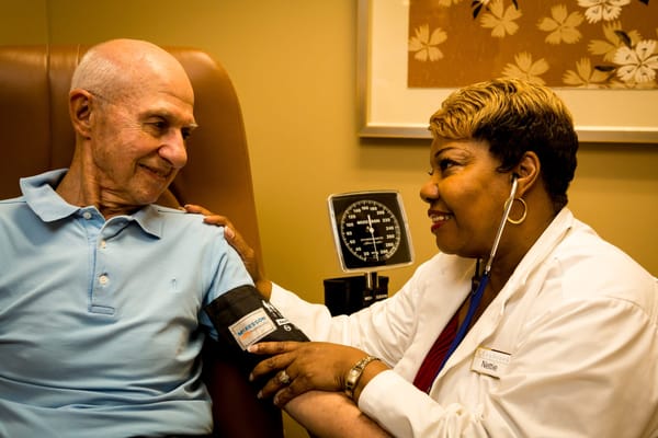 A nurse taking a resident's blood pressure in a clinic
