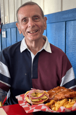 A resident enjoying a meal with fries and vegetables