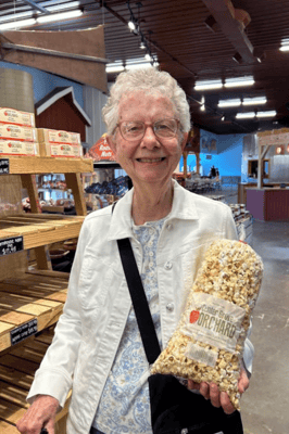 Resident smiling while holding a bag of popcorn
