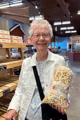Resident smiling while holding a bag of popcorn
