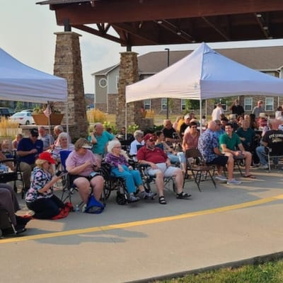 Residents enjoying an outdoor community event under tents