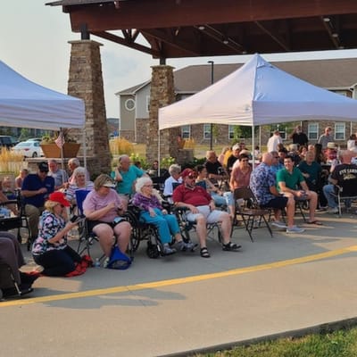 Residents enjoying an outdoor community event under tents