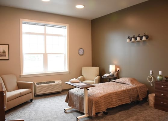 A private resident room with a bed and seating