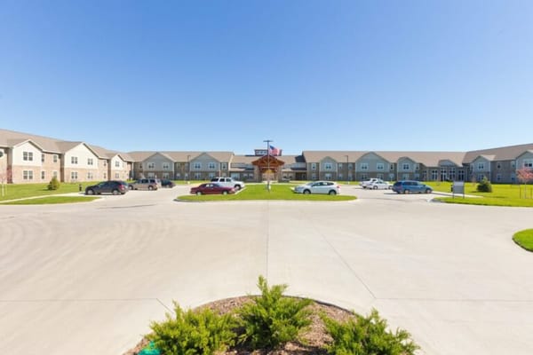 Exterior view of a senior living facility with cars in the parking lot