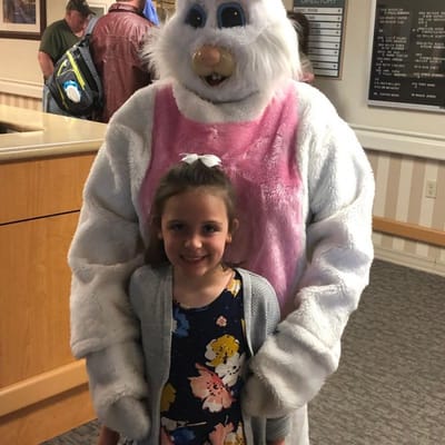 Child with an Easter bunny mascot in a lobby area